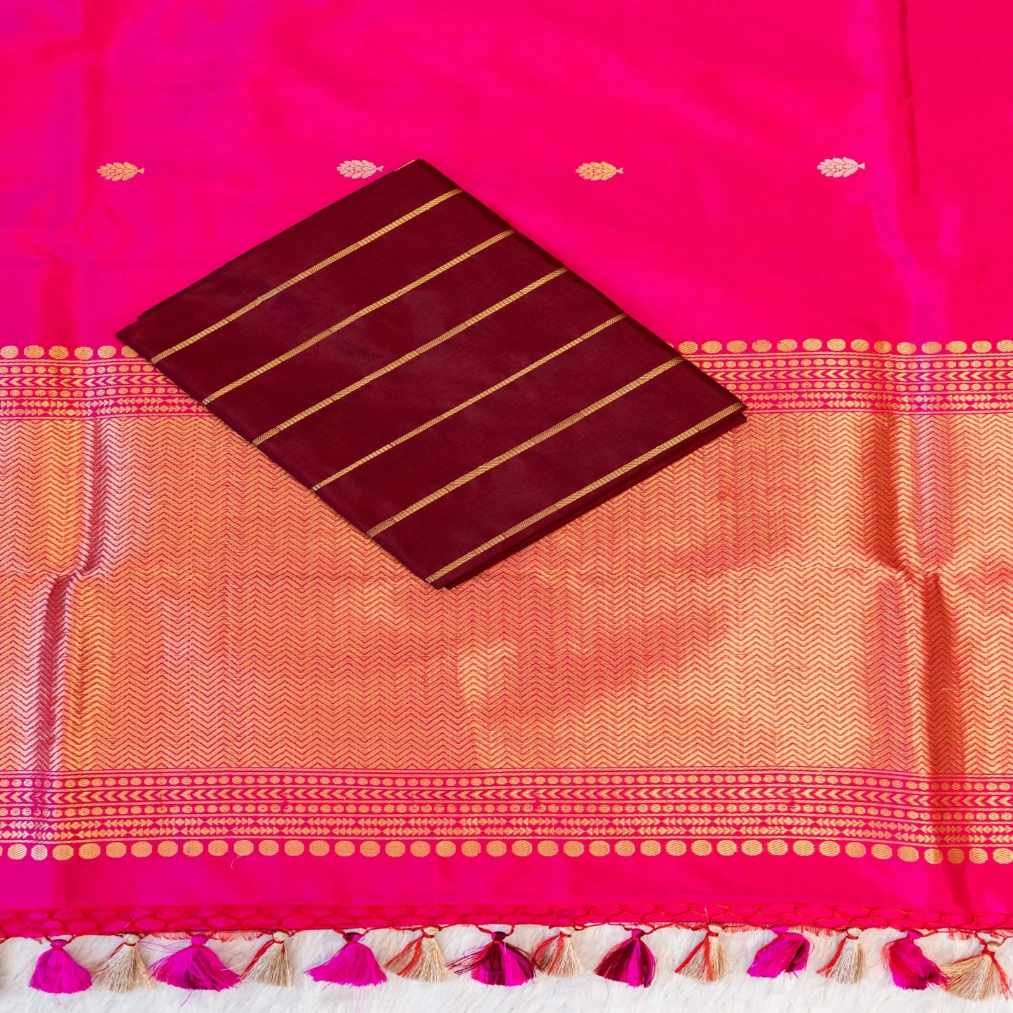 Saree with pink and orange patterned fabric and a maroon card with gold lines.