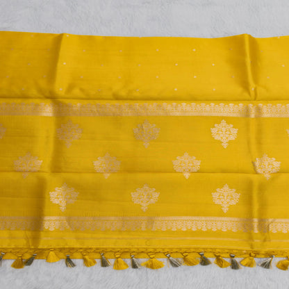 Yellow fabric with gold patterns and tassels on a white background