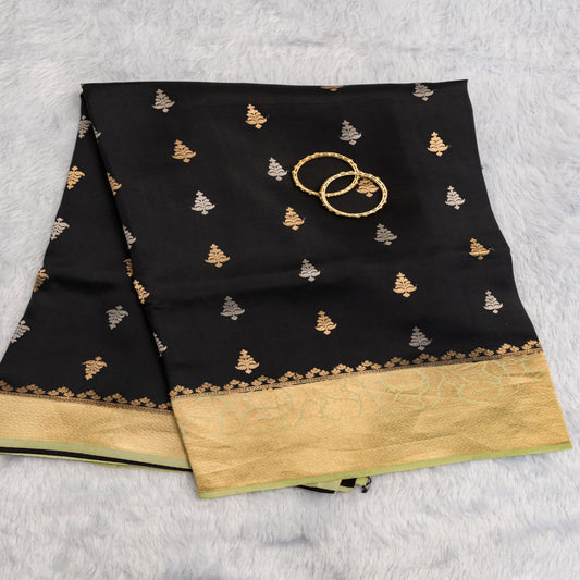 Black saree with gold and white patterns on a light gray background