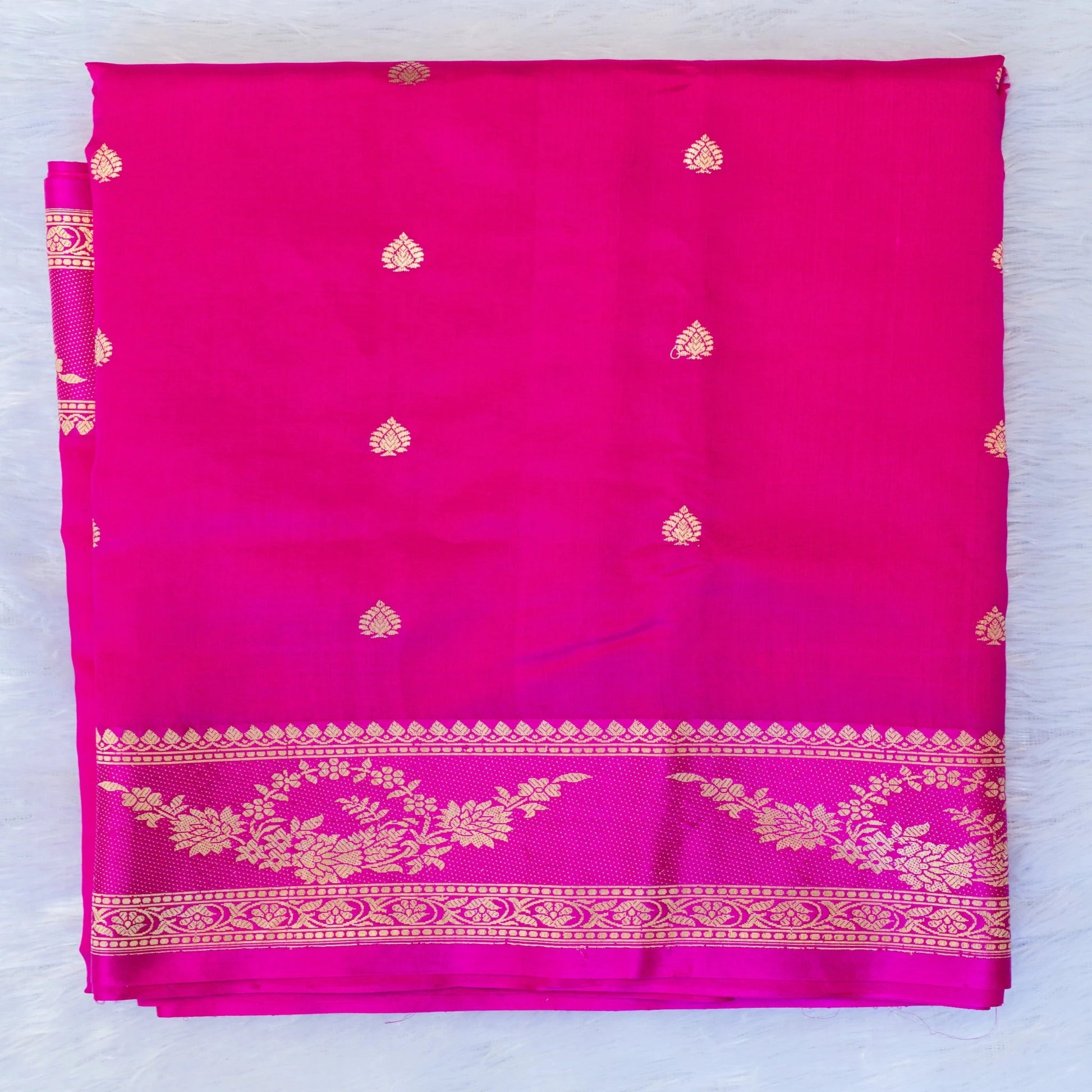 Pink fabric with gold patterns on a light blue background