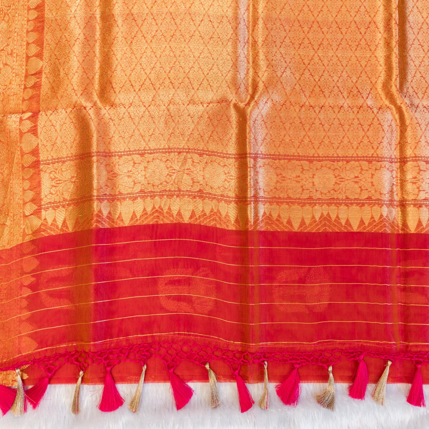 Orange and red fabric with tassels on a white background