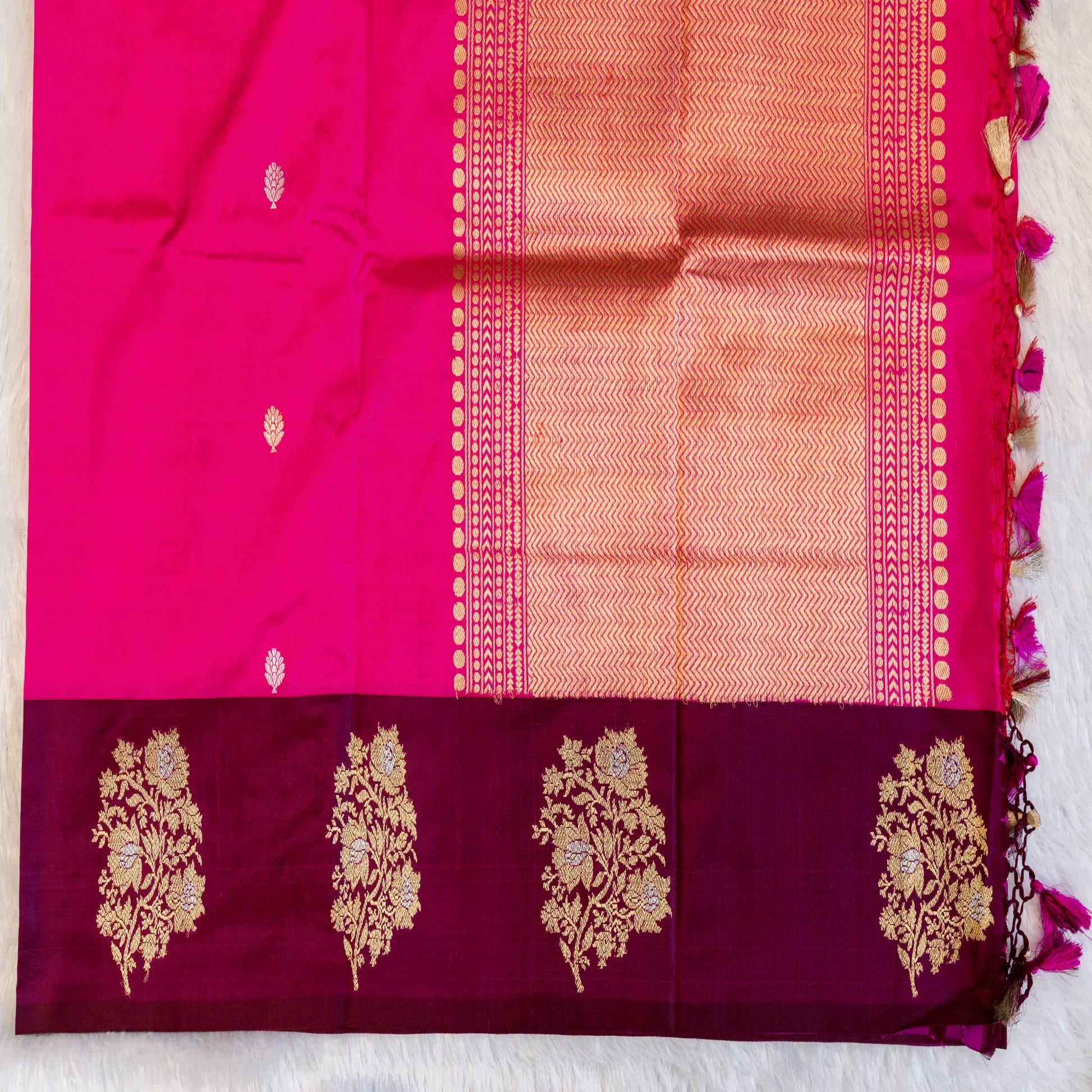 Saree with maroon and pink fabric and gold floral patterns on a white background