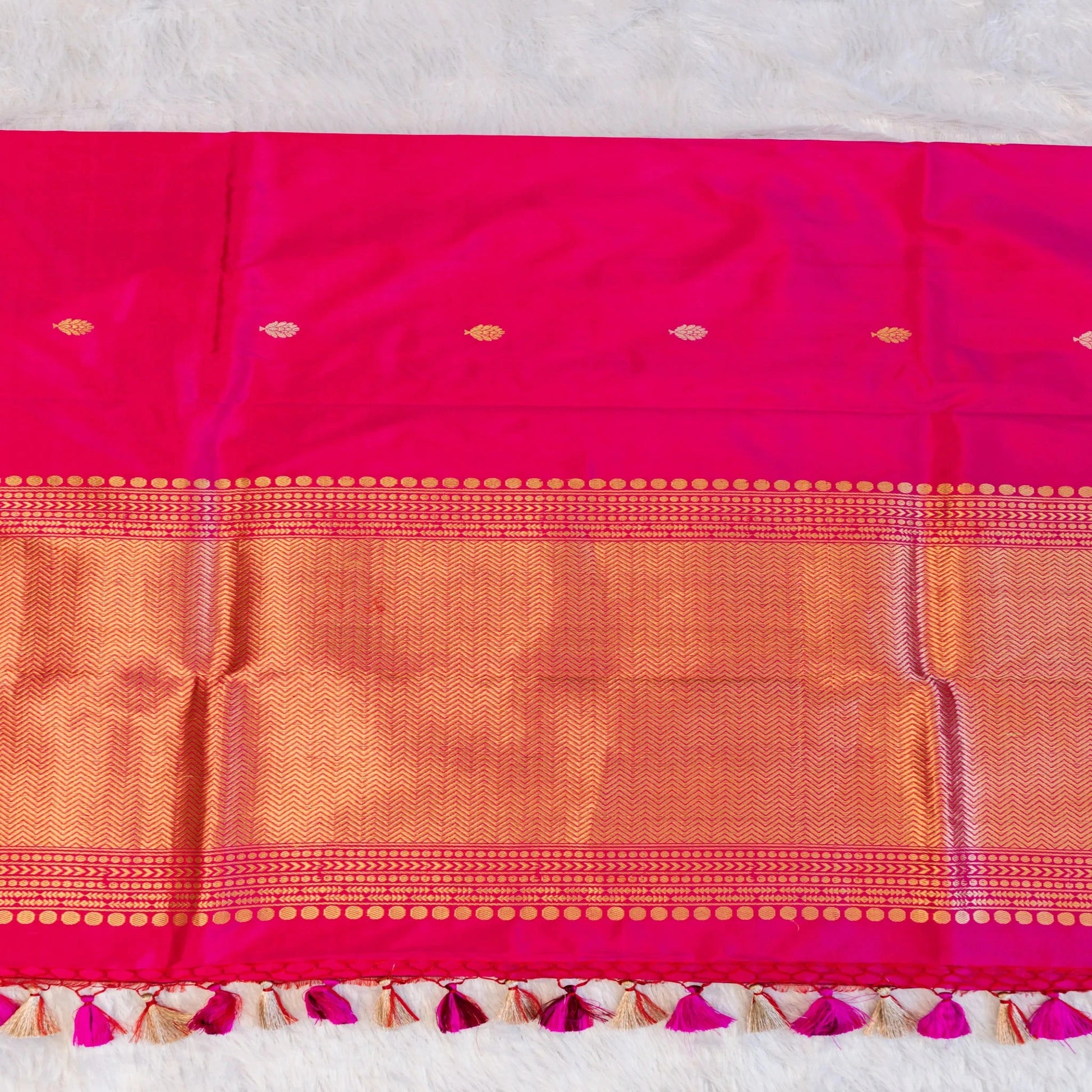 Pink and orange saree with decorative border on a light gray background