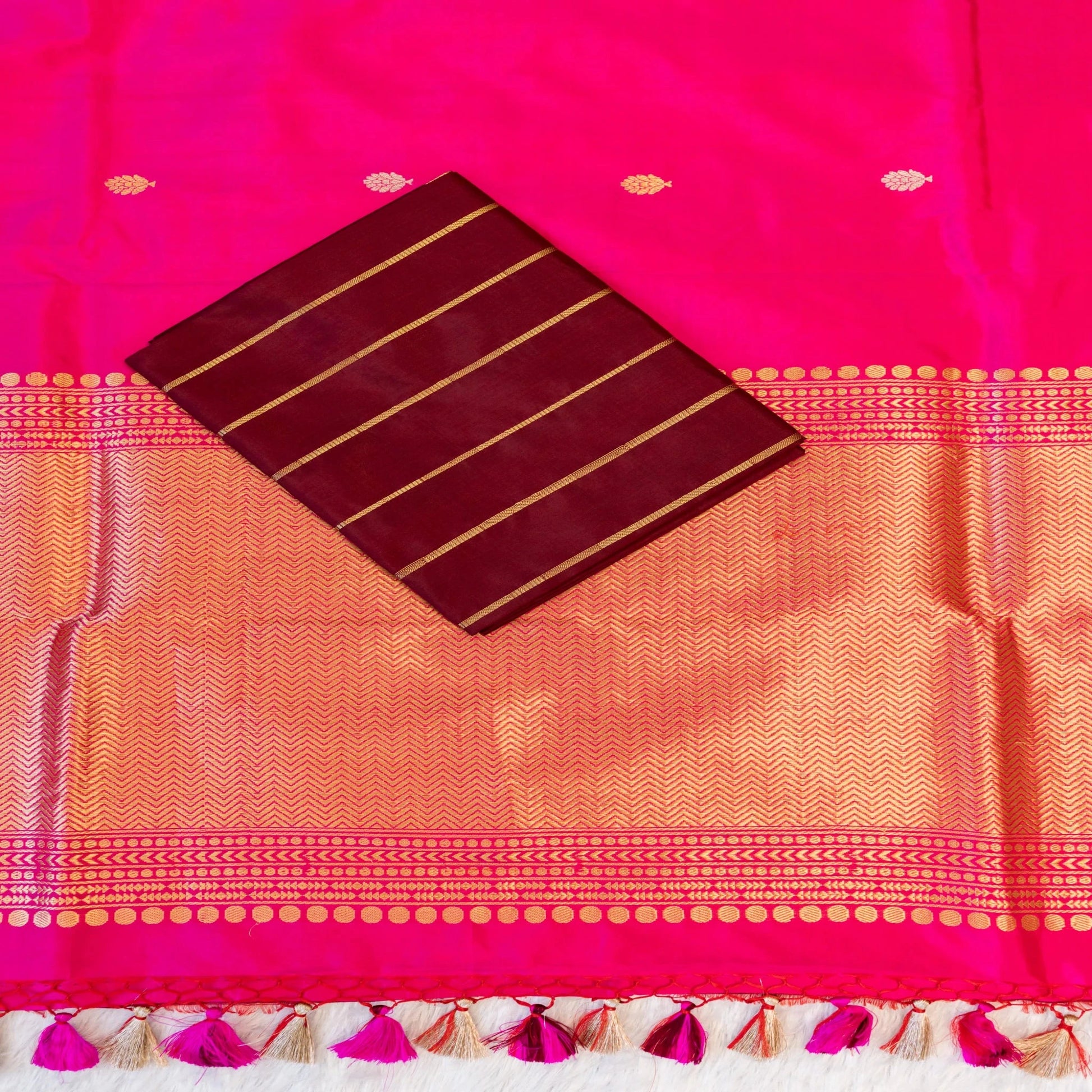 Saree with pink and orange patterned fabric and a maroon card with gold lines.