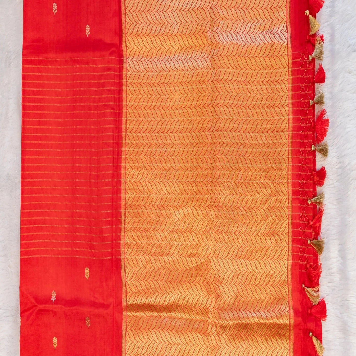 Red and orange saree with decorative border on a white background