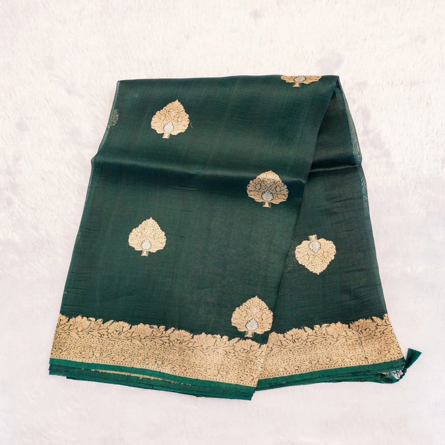 Green fabric with gold embroidery on a white background