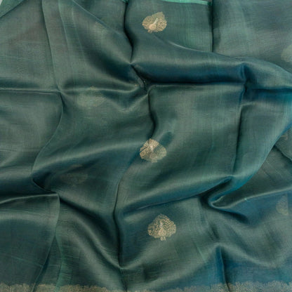 Teal fabric with gold floral patterns, possibly a sari or fabric swatch.