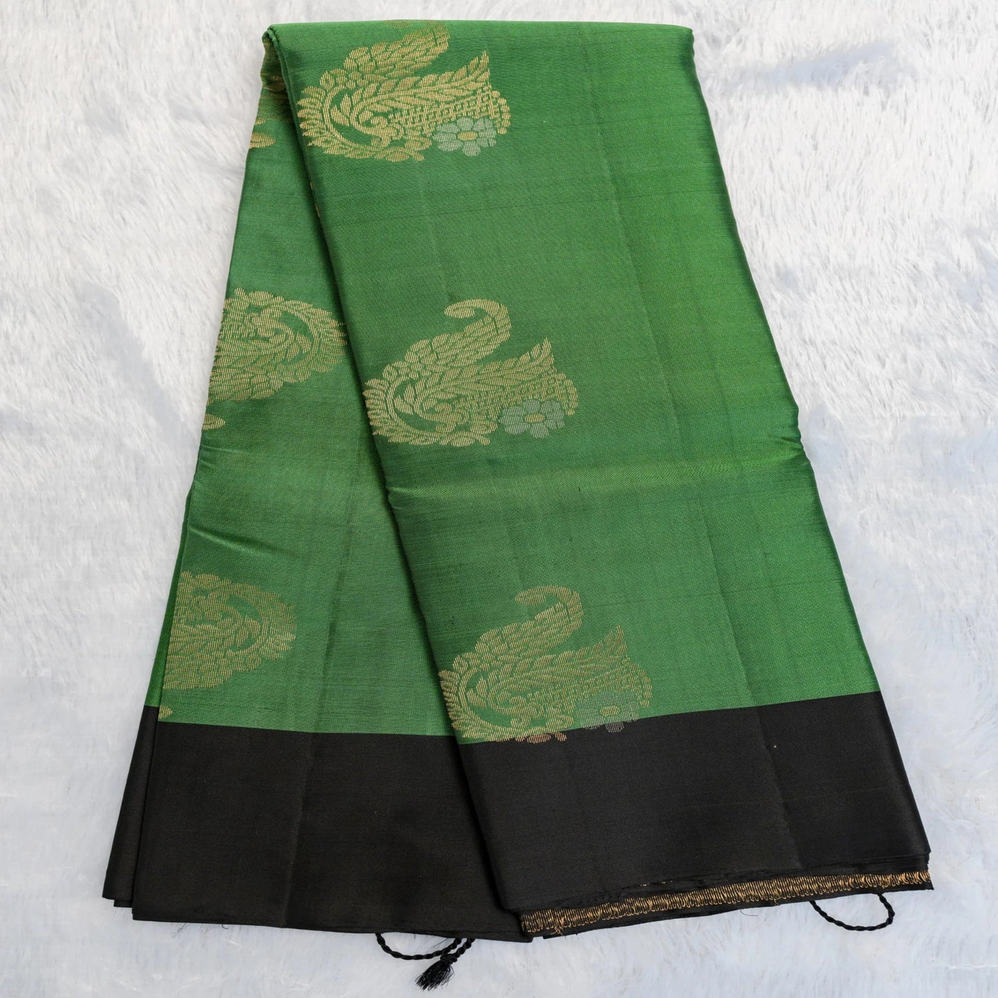 Green and black fabric with gold patterns on a white background