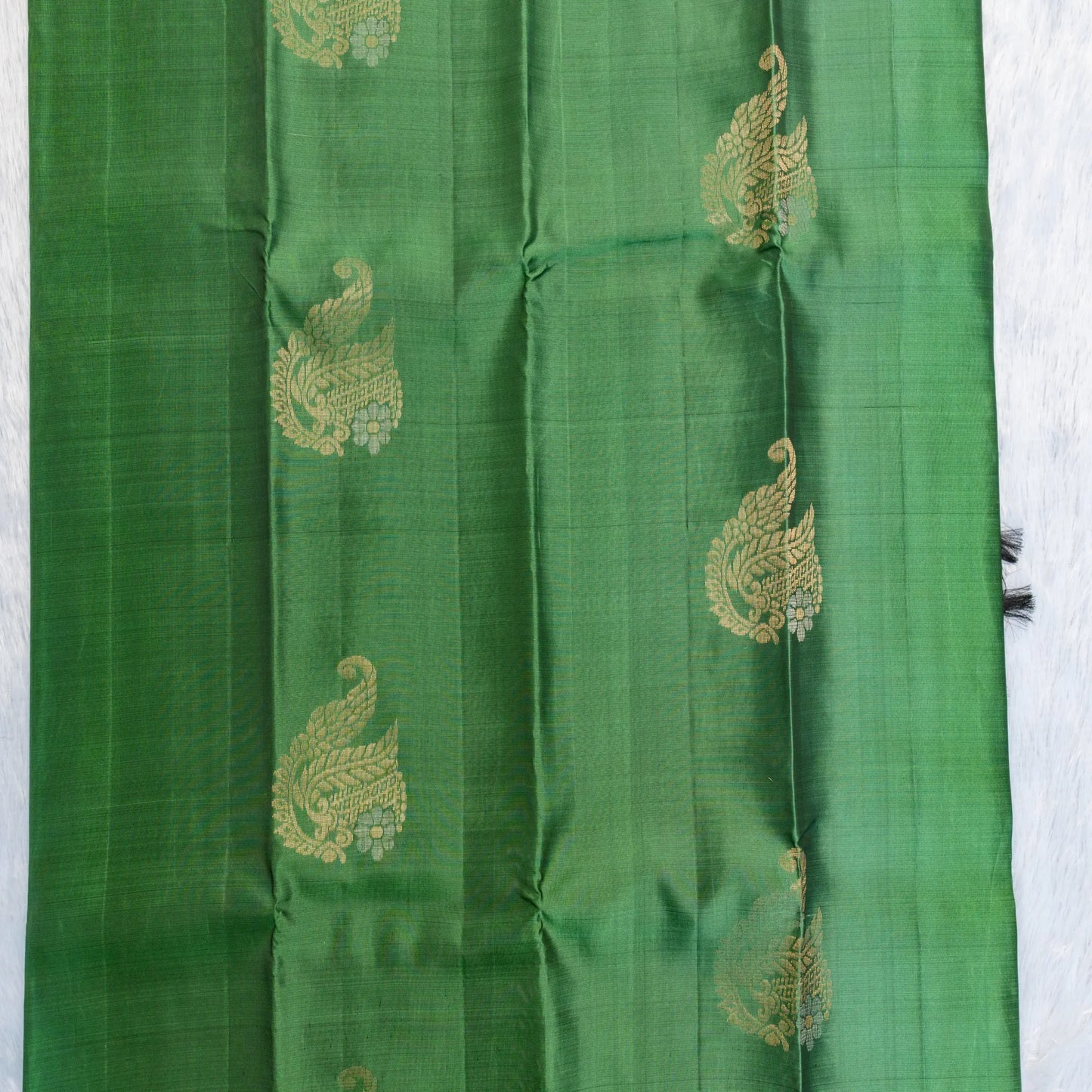 Green fabric with gold embroidery on a white background