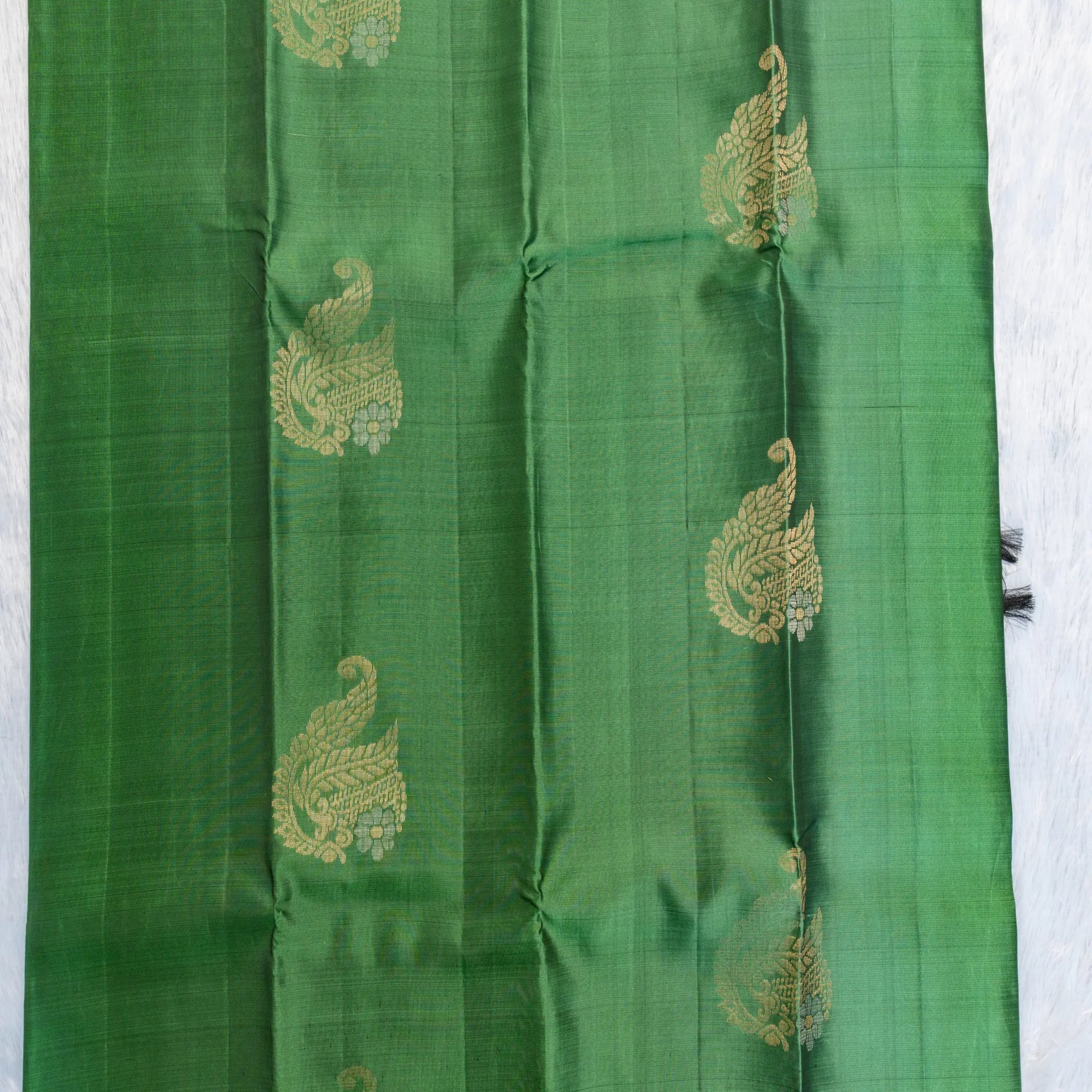 Green fabric with gold embroidery on a white background