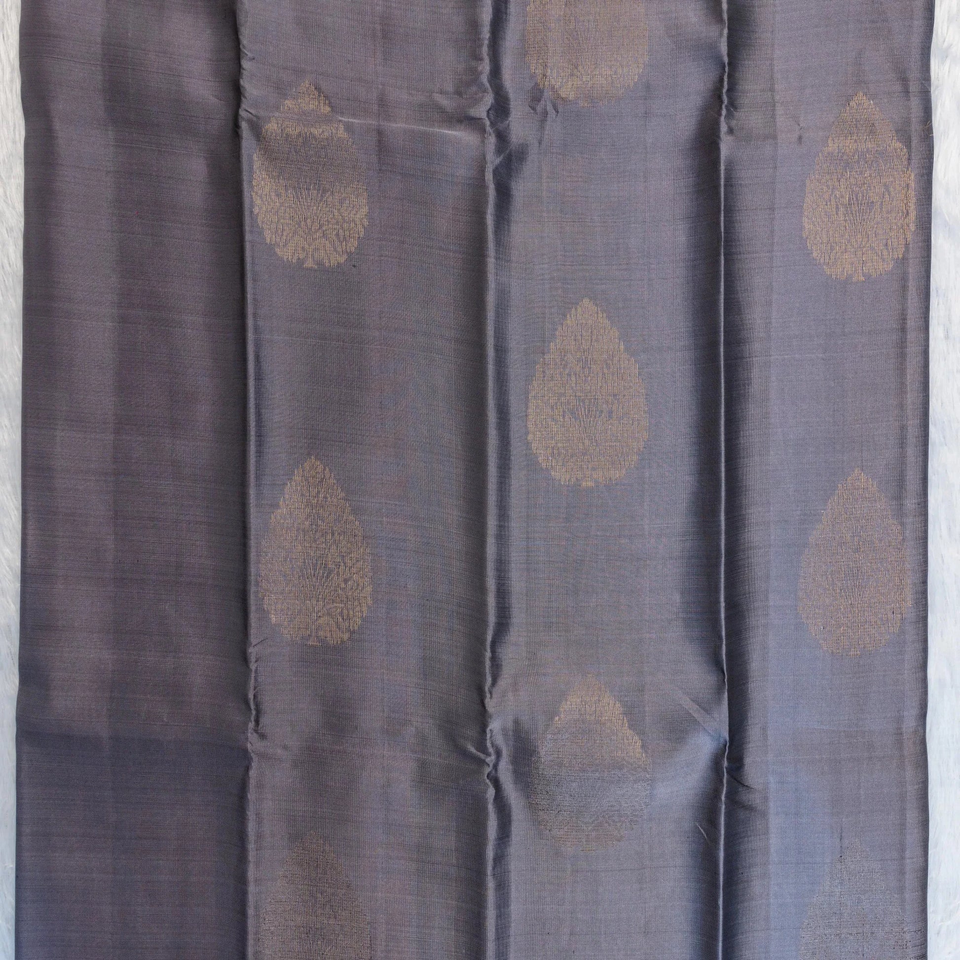 Dark gray fabric with gold circular patterns on a light gray background