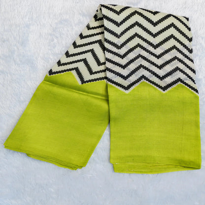 Two green napkins with black and white zigzag patterns on a textured white surface.