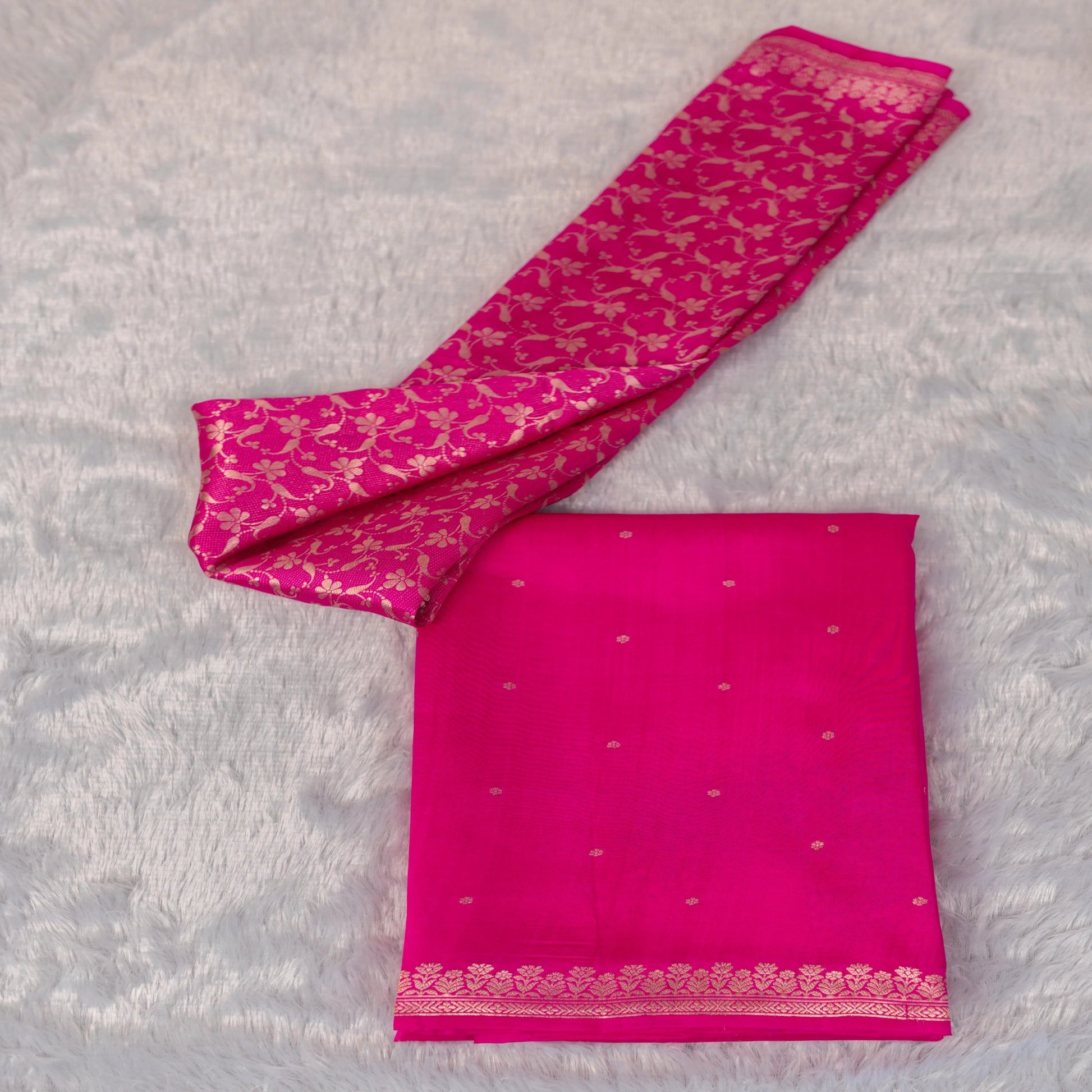 Pink saree with gold patterns on a gray background