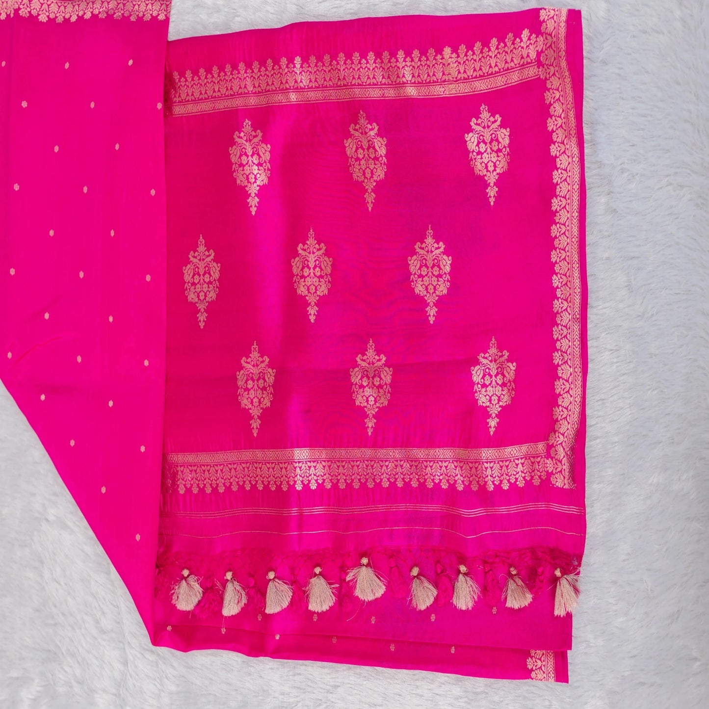 Pink fabric with gold embroidery on a gray background