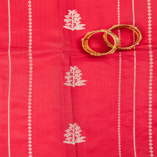 Red fabric with white patterns and gold bangles on a red background