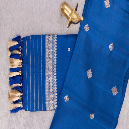 Blue fabric with gold embroidery and tassels on a textured surface